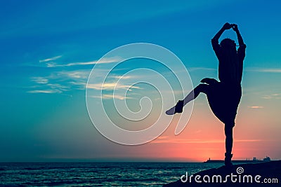 Young woman in sunglasses with blonde dreadlocks sitting thoughtfully on the street outside the clothing store. Stock Photo