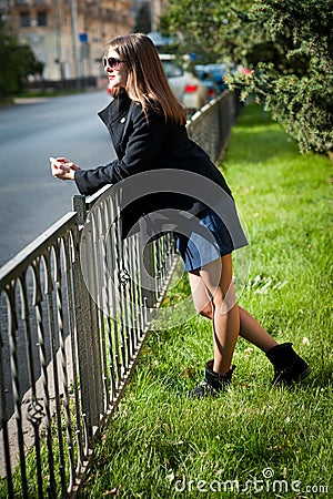 Young woman in sunglasses and metall fence Stock Photo