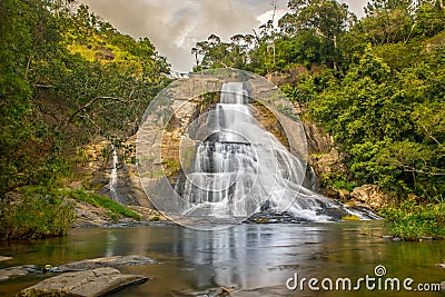 Young woman in a Sunny day in the Tropical waterfall falls from the mountain cliff to the jungle, serene landscape of Diyaluma fal Editorial Stock Photo