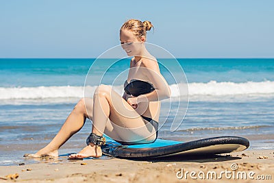 Young woman surfer getting on the surfboard`s leash Stock Photo