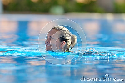 Young woman swimming in the pool on a warm summer day Stock Photo