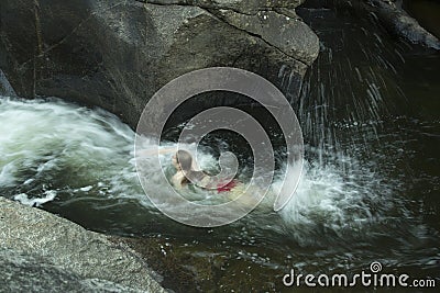 Young woman swimming upstream, against current, Sugar River, New Stock Photo