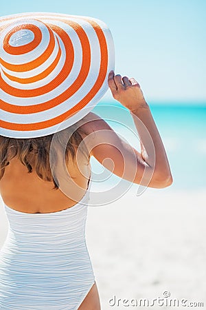 Young woman in swimsuit beach hat looking into distance Stock Photo