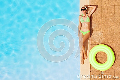 Young woman in swimsuit relaxing by swimming pool Stock Photo