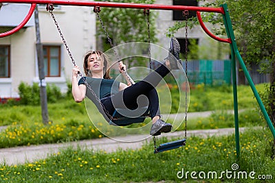 Young woman swinging on swing in the park with copy space. Freedom and happiness concept Stock Photo