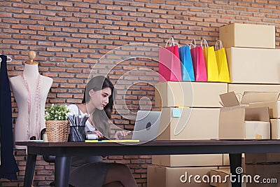 Young woman tailor with laptop is answering emails, Business woman entrepreneurial success . Sales Online Parcel delivery Stock Photo