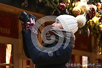 Young woman takes pictures on camera at New Year market Stock Photo