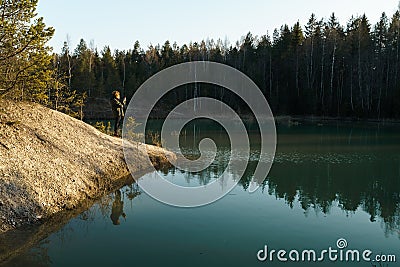 Young woman takes travel photos -Beautiful turquoise lake in Latvia - Meditirenian style colors in Baltic states - Stock Photo