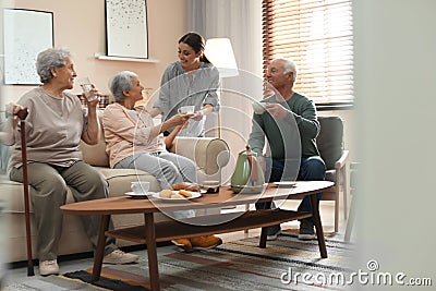 Young woman taking care of elderly people in room Stock Photo