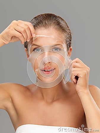 Young woman taking off peeling mask Stock Photo