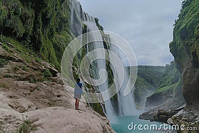 young woman taking picture,Amazing crystalline blue water of Tamul waterfall at Huasteca Potosina in San Luis Potosi, Mexico Stock Photo