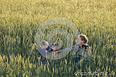 Young woman taking pictures of a child in a field Stock Photo