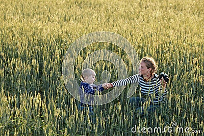 Young woman taking pictures of a child in a field Stock Photo