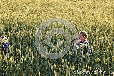 Young woman taking pictures of a child in a field Stock Photo