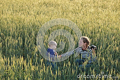 Young woman taking pictures of a child in a field Stock Photo