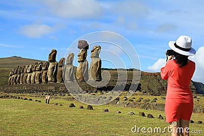 Young woman taking pictures of the famous Moai statues at Ahu Tongariki on Easter Island Stock Photo