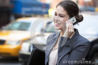 Young Woman Talking on Cell Phone by Yellow Taxi Stock Photo