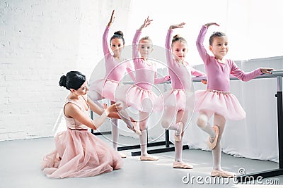 young woman teaching adorable children dancing in ballet Stock Photo