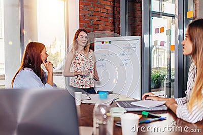 Young woman teaching English to adult students at language school Stock Photo