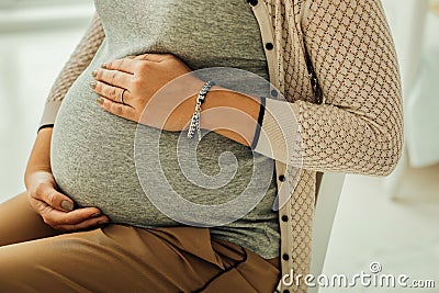 Young woman touching her third-trimester pregnant belly Stock Photo