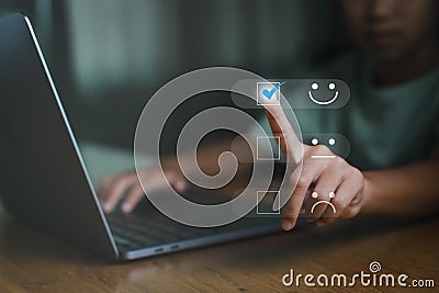 Young woman is touching the virtual screen on the happy Smiley face icon to give satisfaction in service. Best excellent services Stock Photo