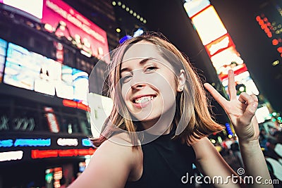 Young woman tourist laughing and taking selfie photo in New York City, Manhattan, Times Square Stock Photo