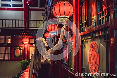 Young woman tourist looks at the Chinese traditional lanterns. Chinese New Year. Travel to China concept Stock Photo