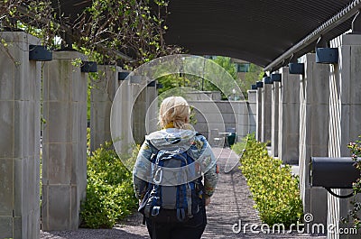 Young woman tourist wearing a backpack wanders through the US Botanical Gardens, exploring the flowers Stock Photo