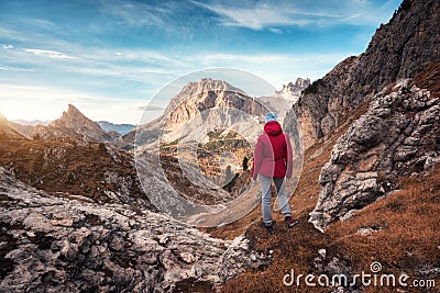 Young woman on the trail looking on high mountain peak at sunset Stock Photo