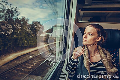 The young woman is on the train and watches through the window o Stock Photo