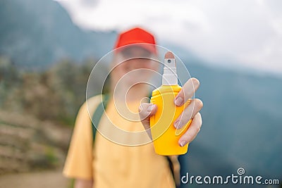 Woman applying insect repellent against mosquito and tick on her hand during hike in nature top mountain. Skin Stock Photo