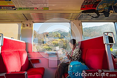 Young woman traveler with backpack holding map planning vacation on holiday relaxation on the train at nikko, Japan. Editorial Stock Photo