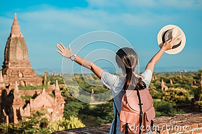 Young woman traveling backpacker with hat, Asian traveler standing on Pagoda and looking Beautiful ancient temples Stock Photo