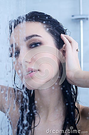 Young woman under shower with water drops Stock Photo