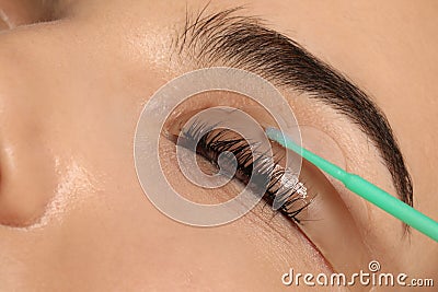 Young woman undergoing eyelash lamination, closeup. Professional service Stock Photo