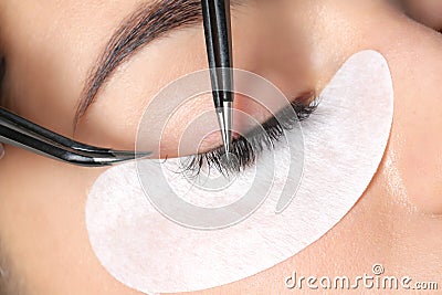 Young woman undergoing eyelashes extensions procedure Stock Photo