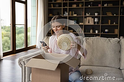 Woman unpacking parcel box with home interior decoration items Stock Photo