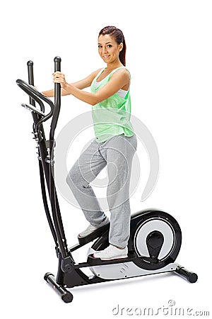 Young woman uses elliptical cross trainer. Stock Photo