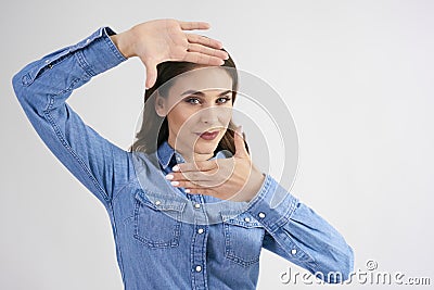 Young woman uses her fingers to frame her face Stock Photo