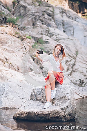 Young woman usin smartphone on the lake Stock Photo