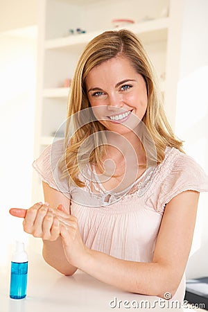 Young woman using hand sanitizer Stock Photo