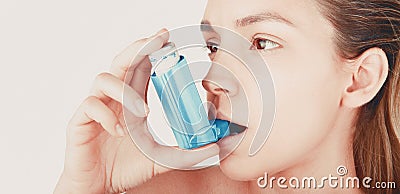 Young woman using inhaler during asthmatic attack at home, closeup, white background Stock Photo