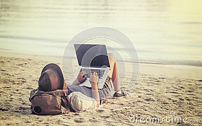 Young woman using laptop computer on a beach. Freelance work con Stock Photo