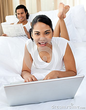 Young woman using a laptop smiling at the camera Stock Photo