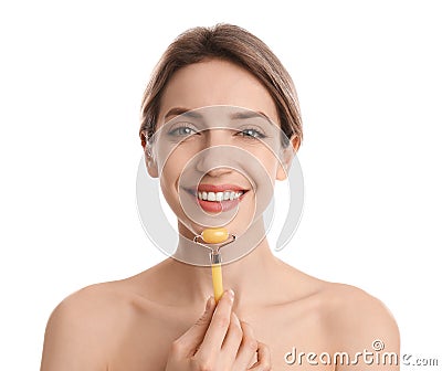 Young woman using natural jade face roller on white background Stock Photo