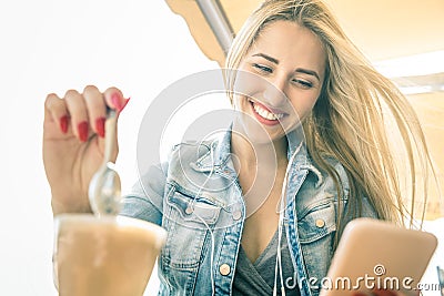 Young woman using smartphone at coffee bar - Fashion blogger girl Stock Photo
