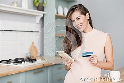 Young woman using smartphone and credit card at home. Businesswoman girl buying with internet. Stock Photo