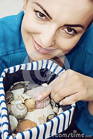 Young woman with various shells in sailor bag Stock Photo