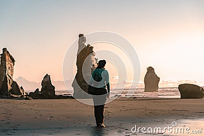 Young woman walking by the beach between big rock formations. Inspirational and travel concept Stock Photo