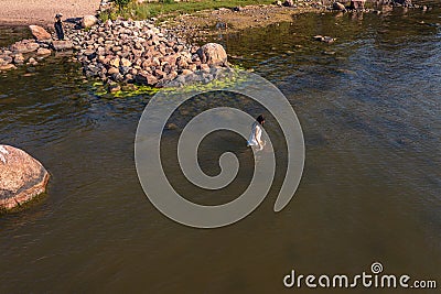 A young woman walks on the water. Lady bathes. Concept of summer vacation, skin and health care, relaxation Stock Photo